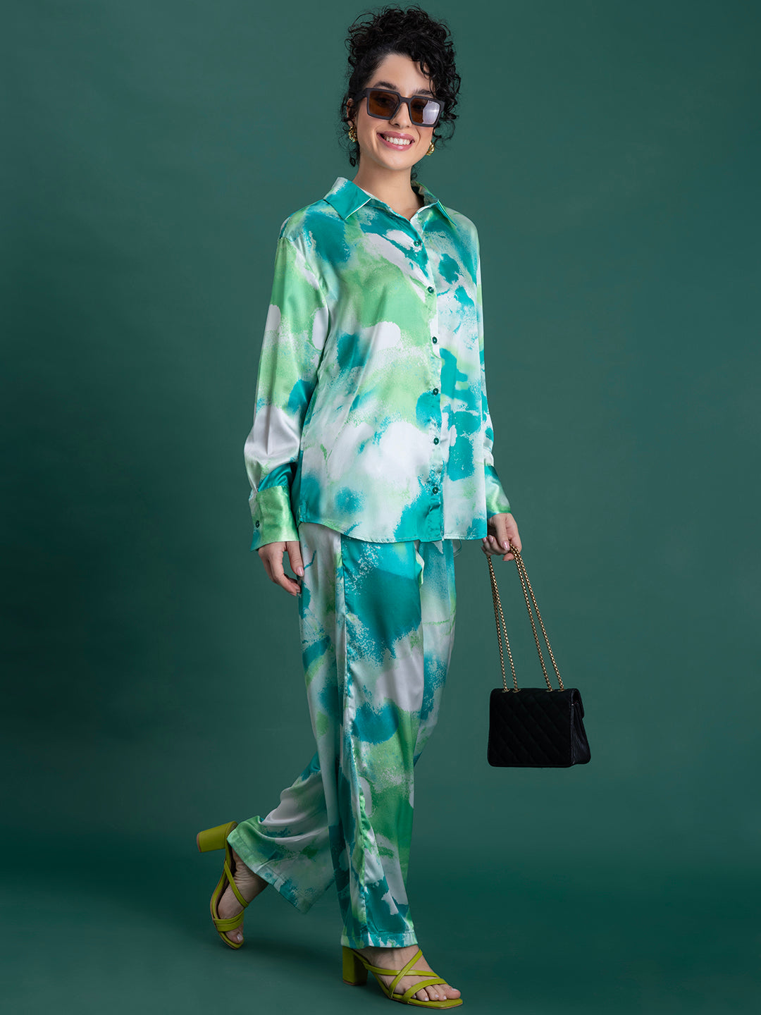 Lifestyle shot of green satin co-ord set styled with heels
