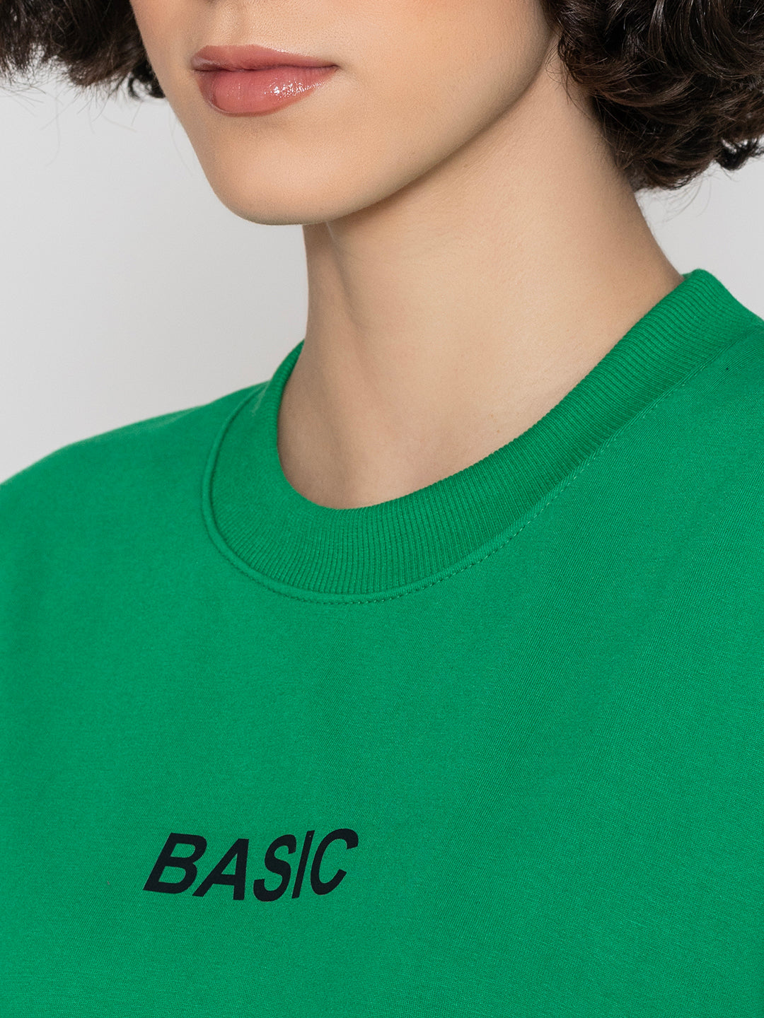 Model wearing green sweatshirt in a casual everyday look
