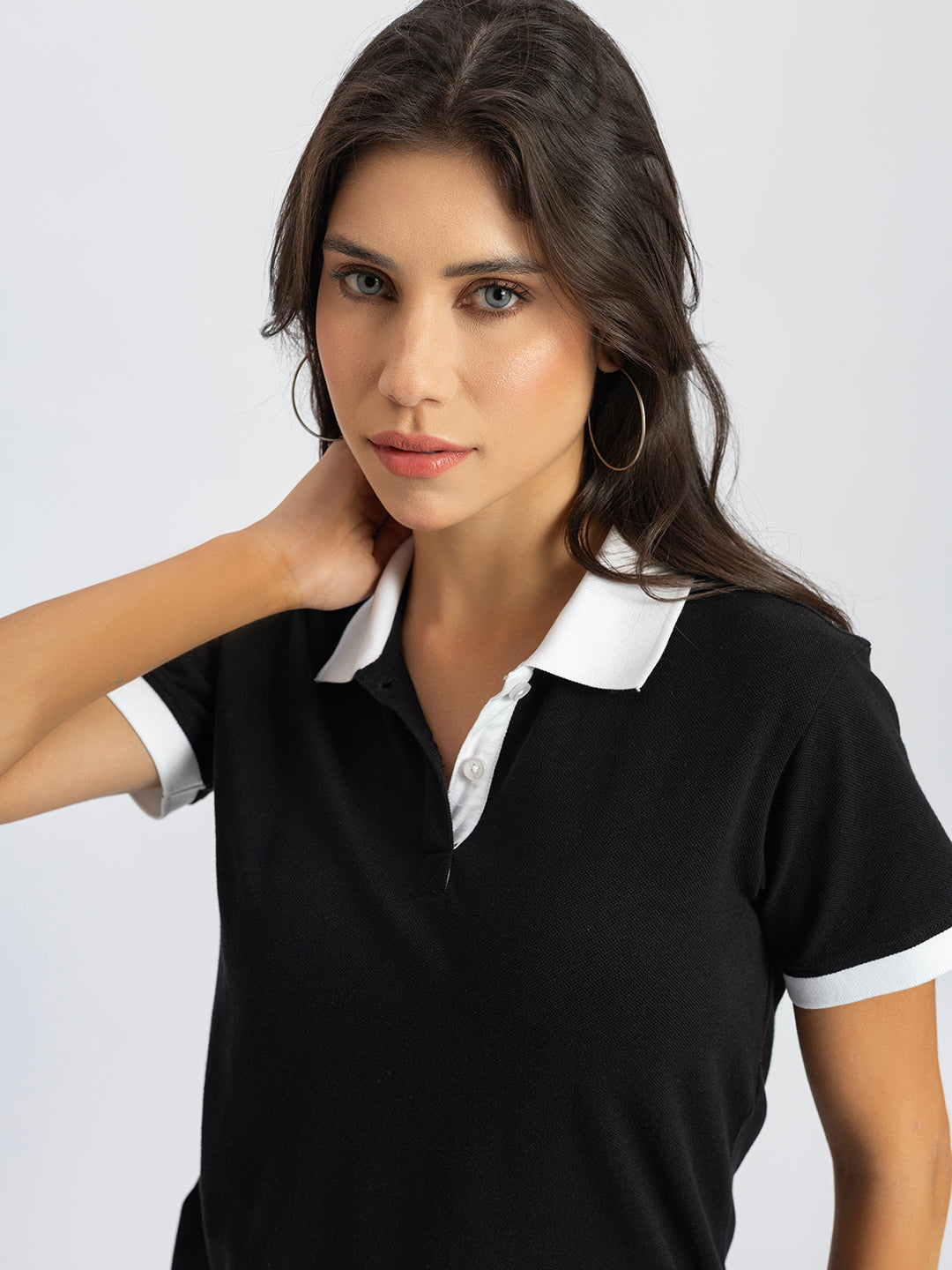 Side view of black polo T-shirt with white contrast collar