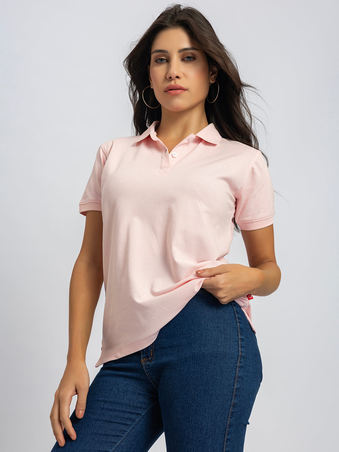 Lifestyle shot of woman wearing light pink polo
