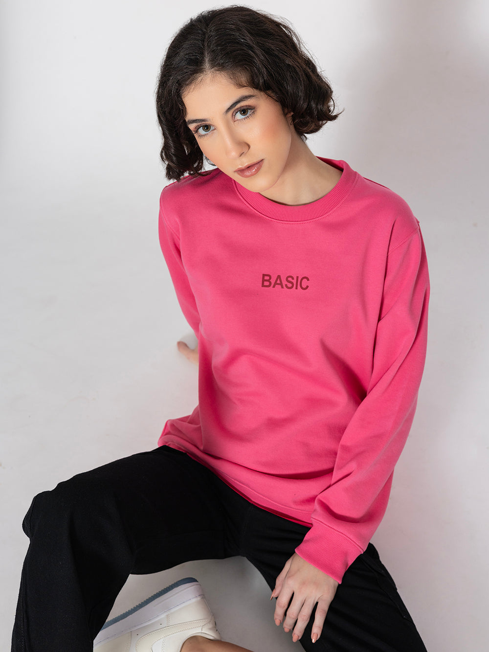 Side view of pink sweatshirt showing relaxed drop-shoulder fit
