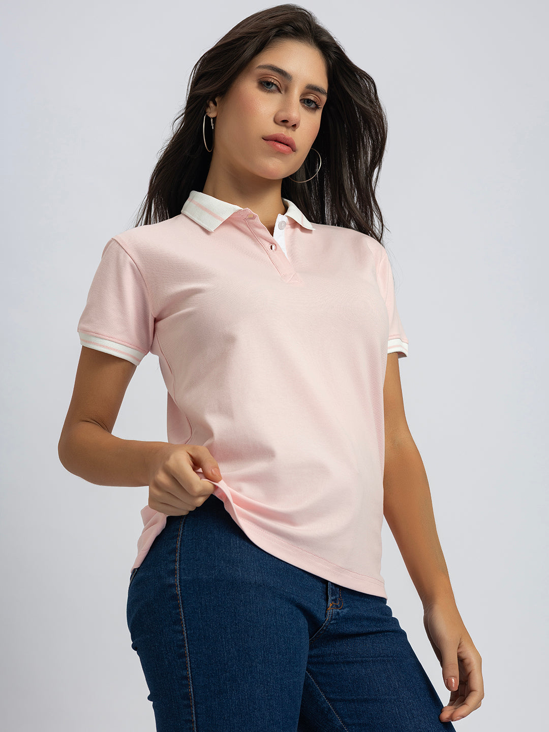 Lifestyle shot of woman wearing light pink striped collar polo