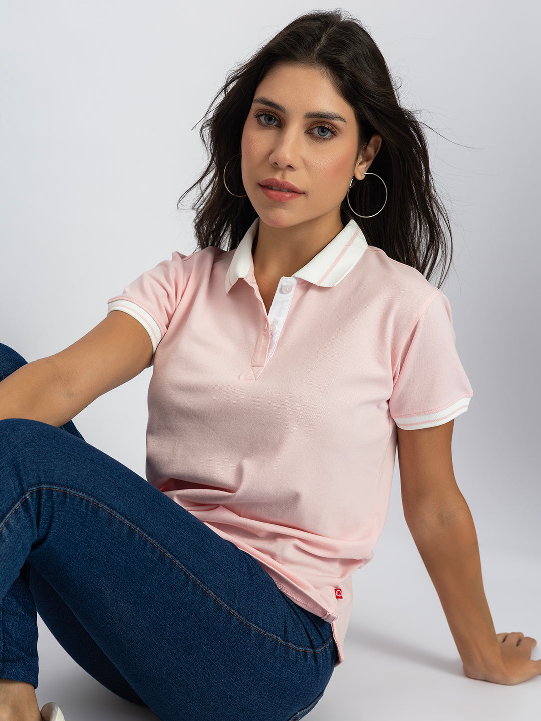 Styling shot of light pink polo with denim
