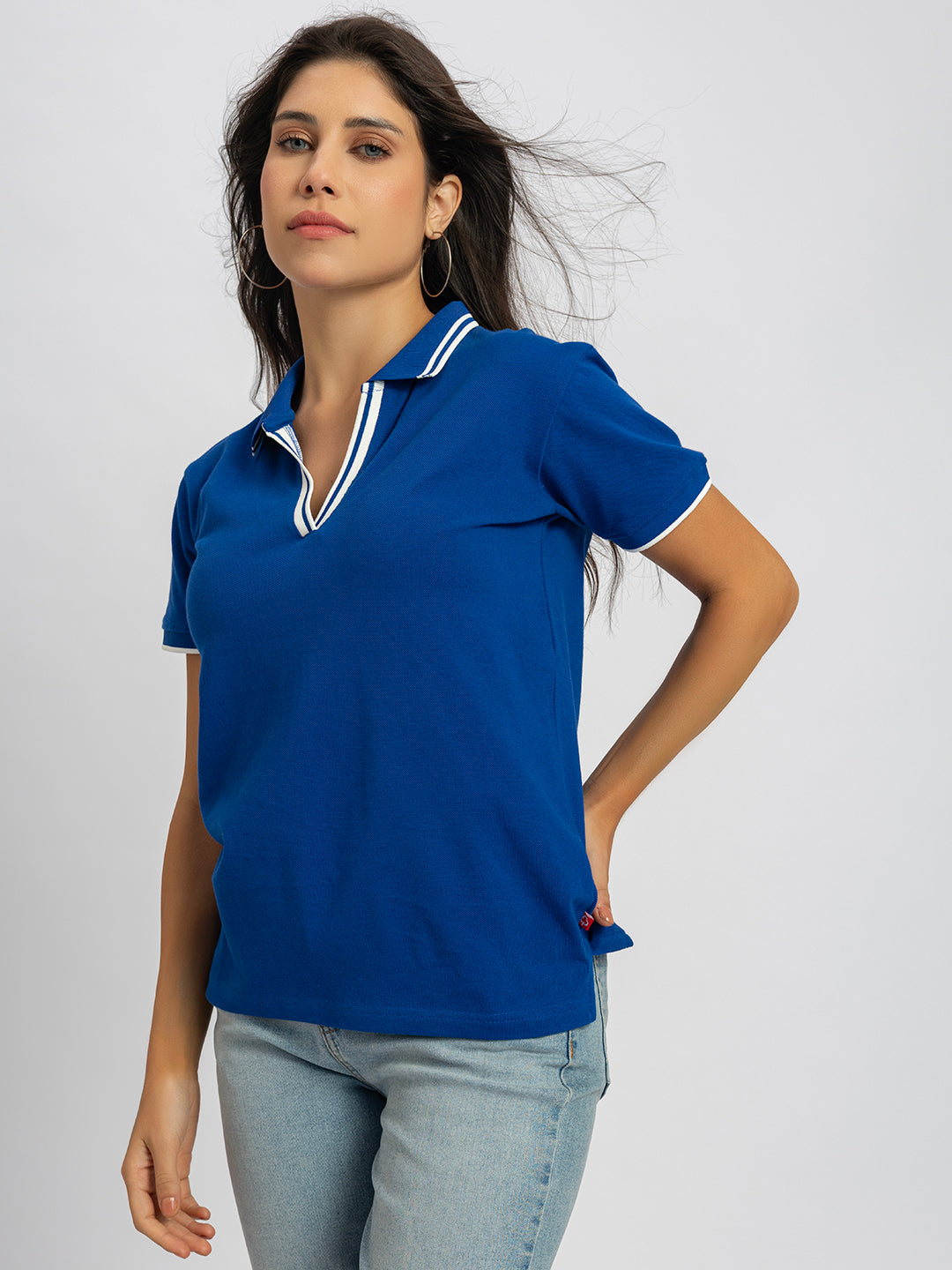Lifestyle shot of woman wearing royal blue striped collar polo