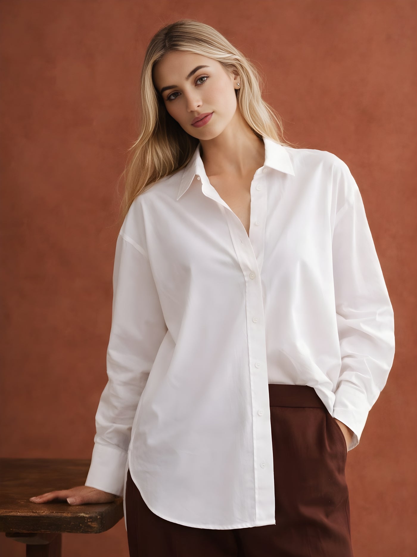 Woman wearing oversized white poplin shirt with drop-shoulder fit and spread collar