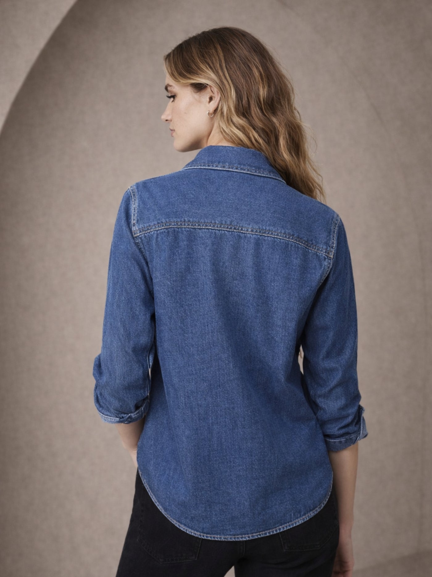 Curved hem detail of dark blue denim shirt