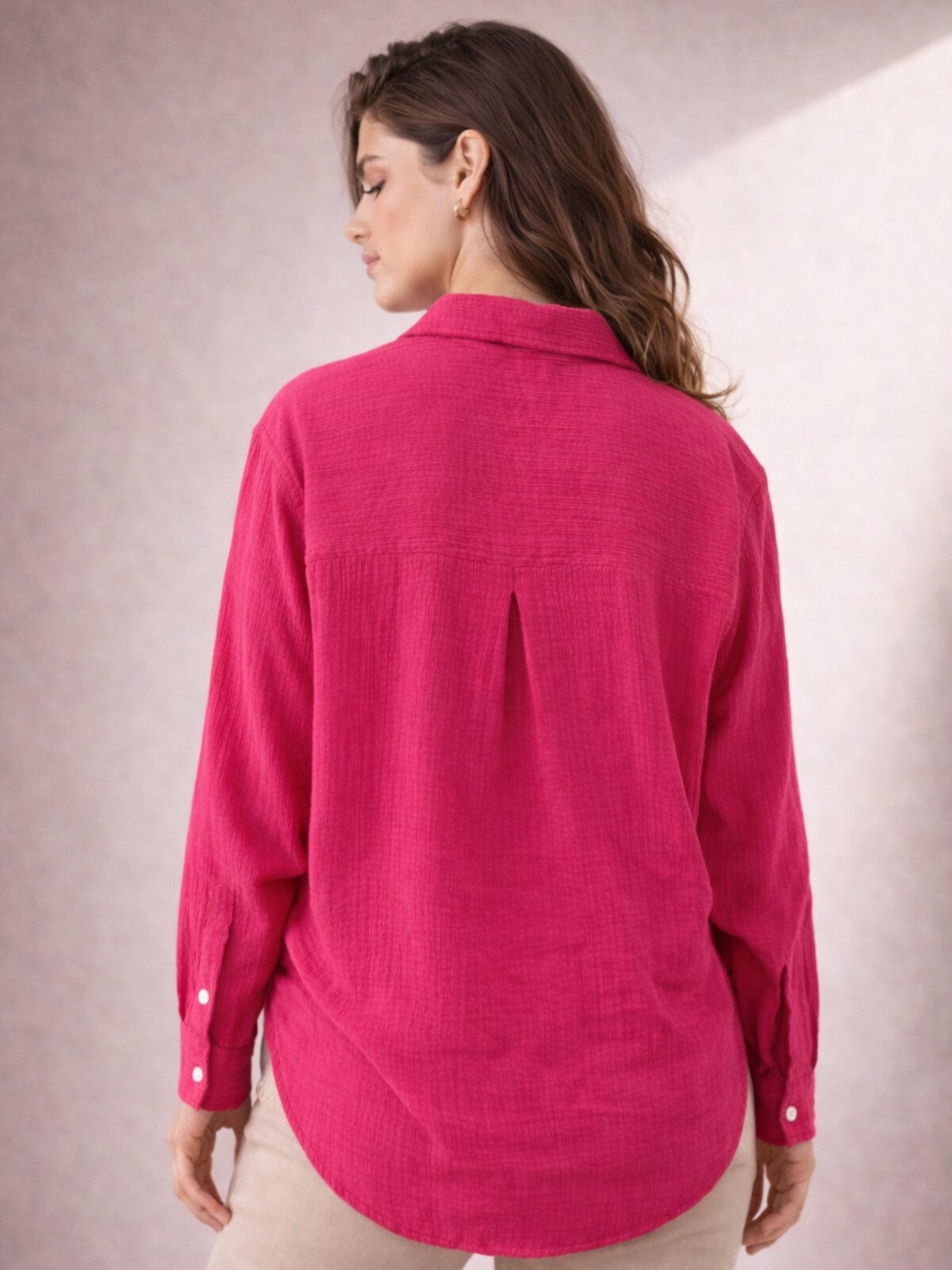 Lifestyle shot of woman wearing pink wrinkled cotton shirt