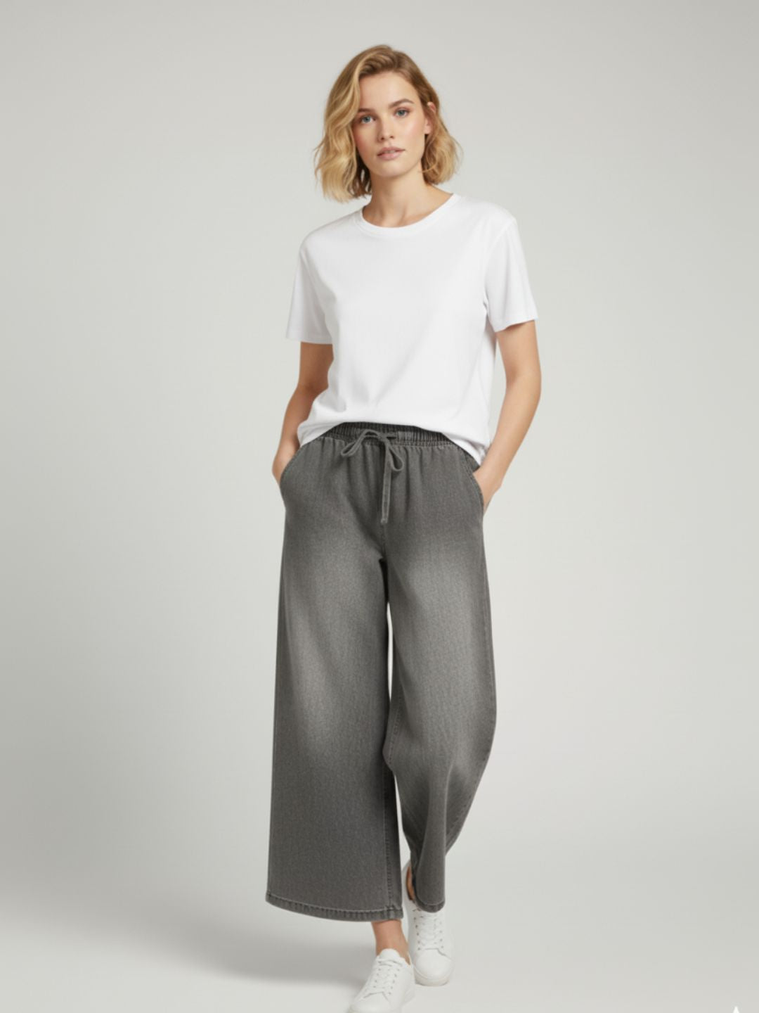 Lifestyle shot of woman wearing grey cotton drawstring trousers casually