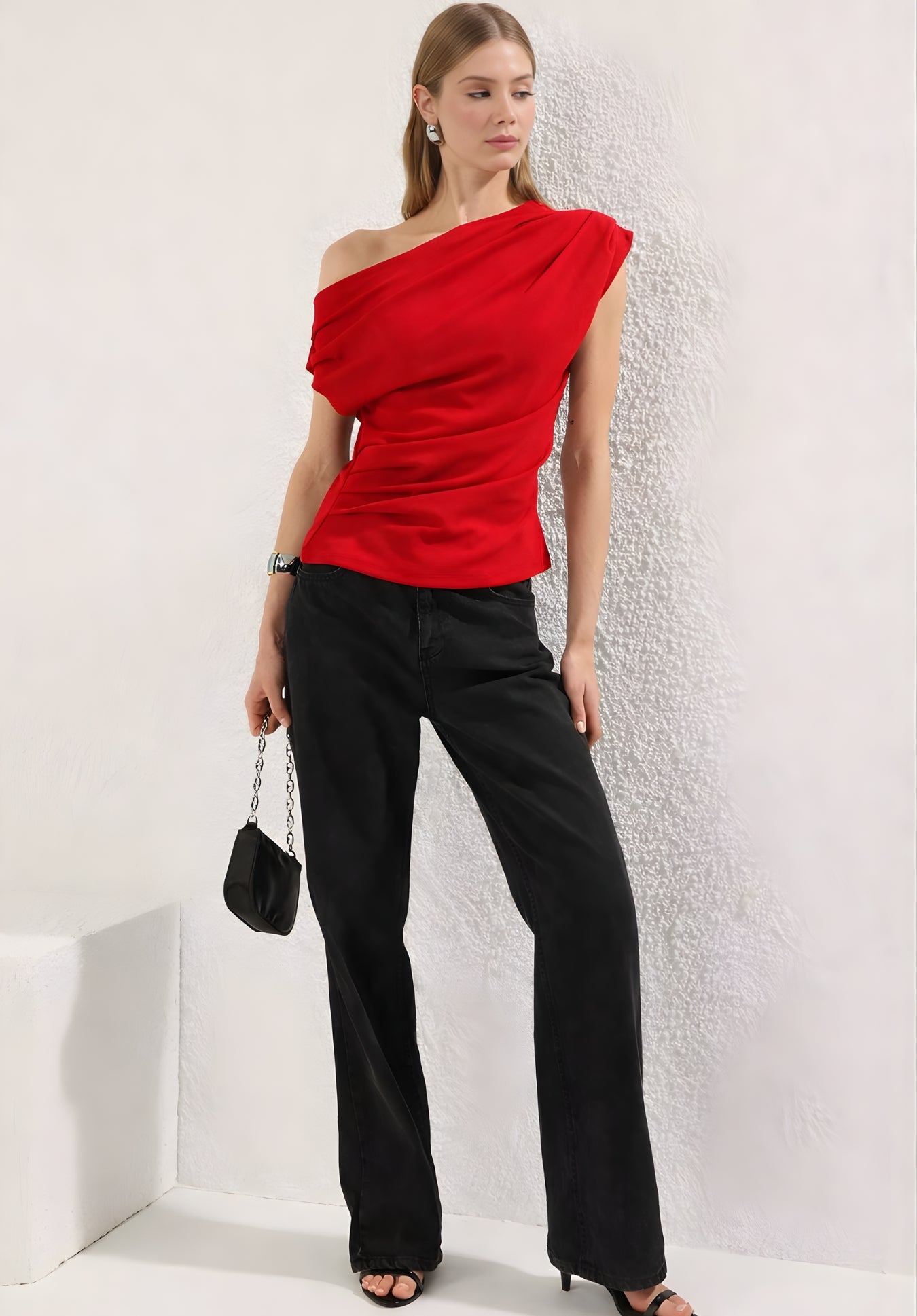 Close-up of asymmetric neckline on red one-shoulder top