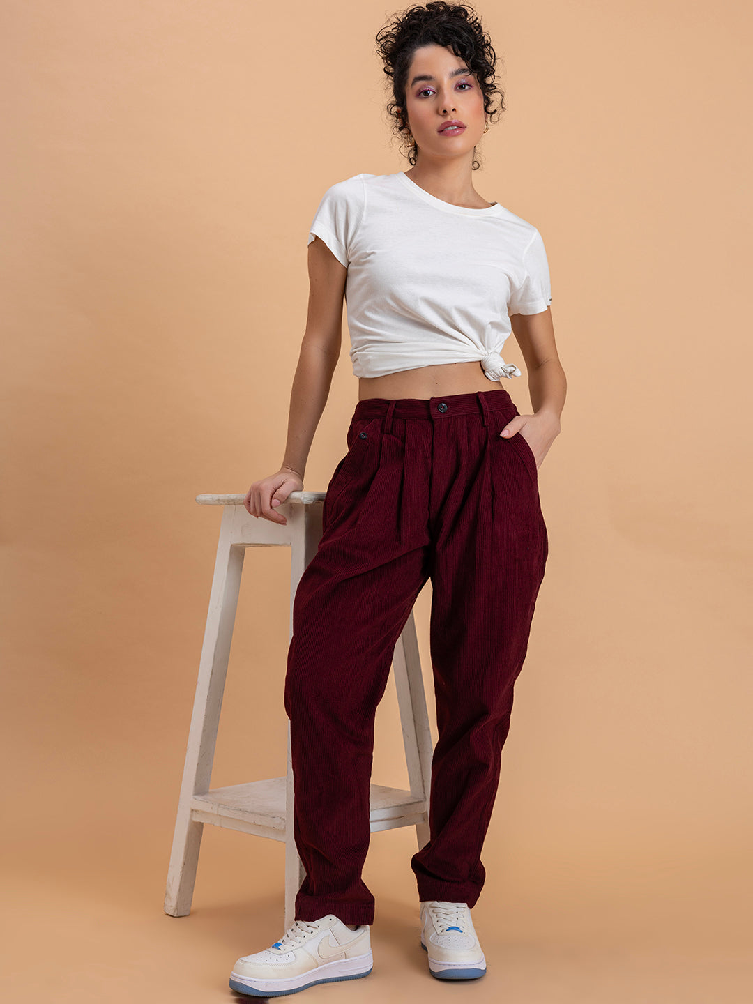Lifestyle shot of maroon corduroy baggy trousers styled casually