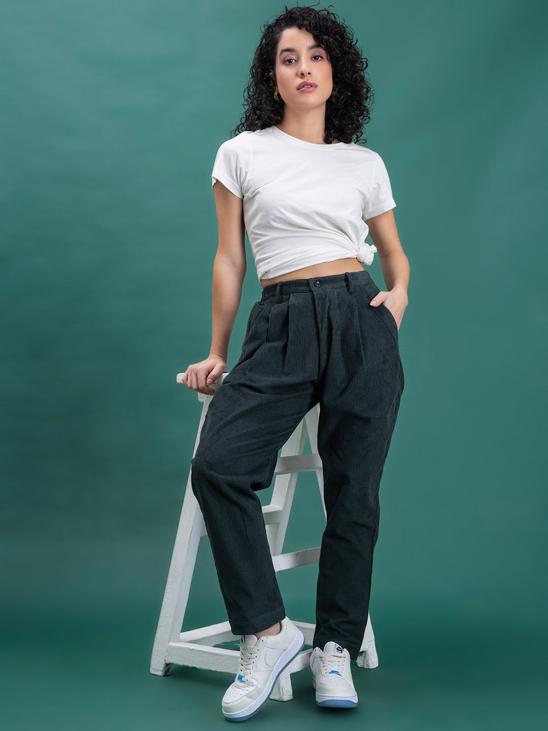 Lifestyle shot of green corduroy baggy trousers styled casually