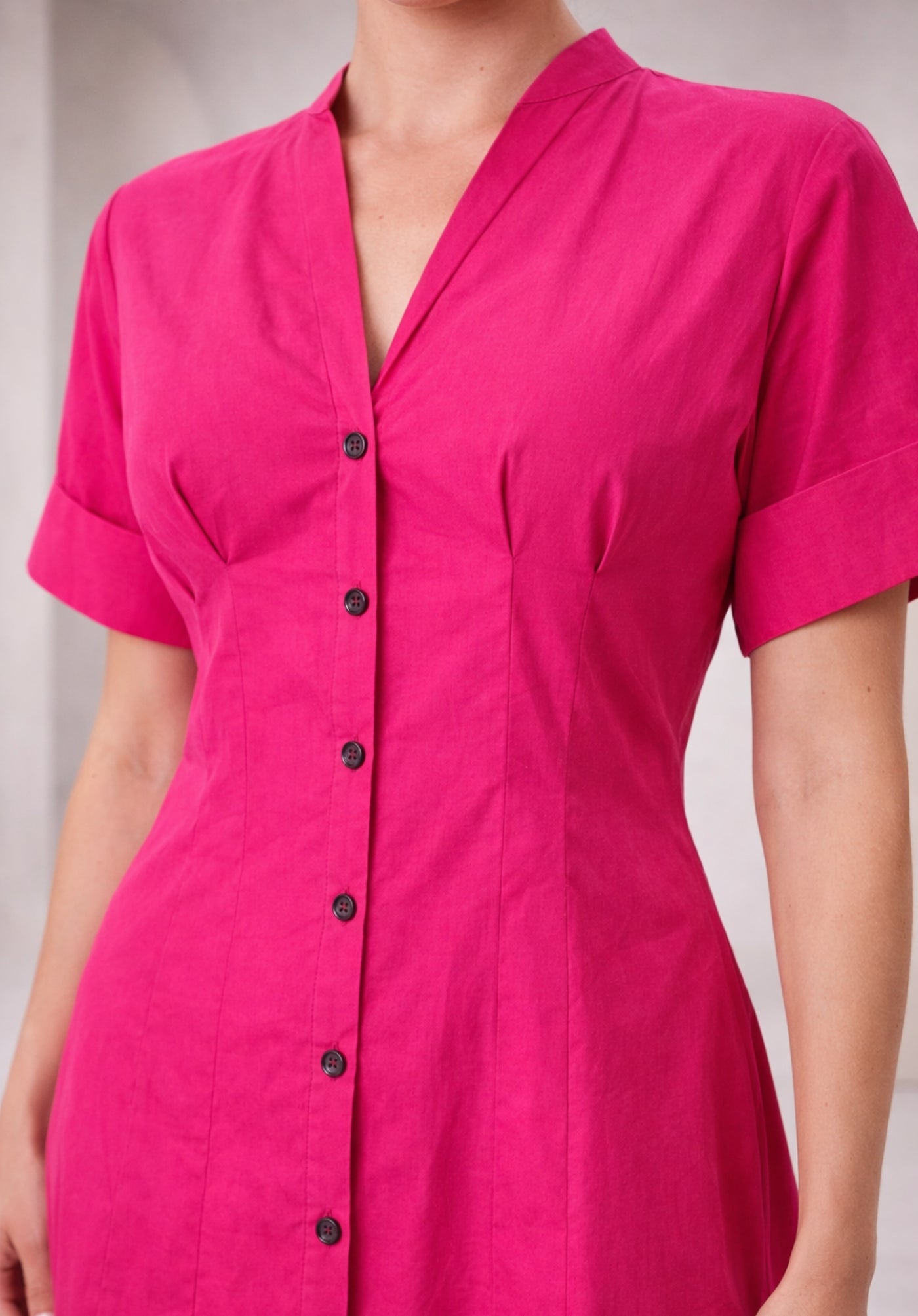 Lifestyle shot of model wearing pink cotton buttoned A-line dress