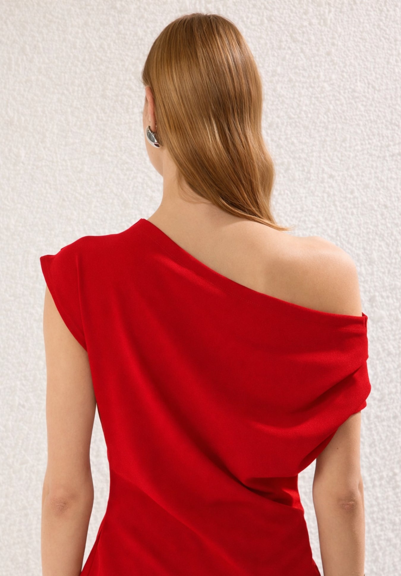 Lifestyle shot of red one-shoulder top styled with jeans