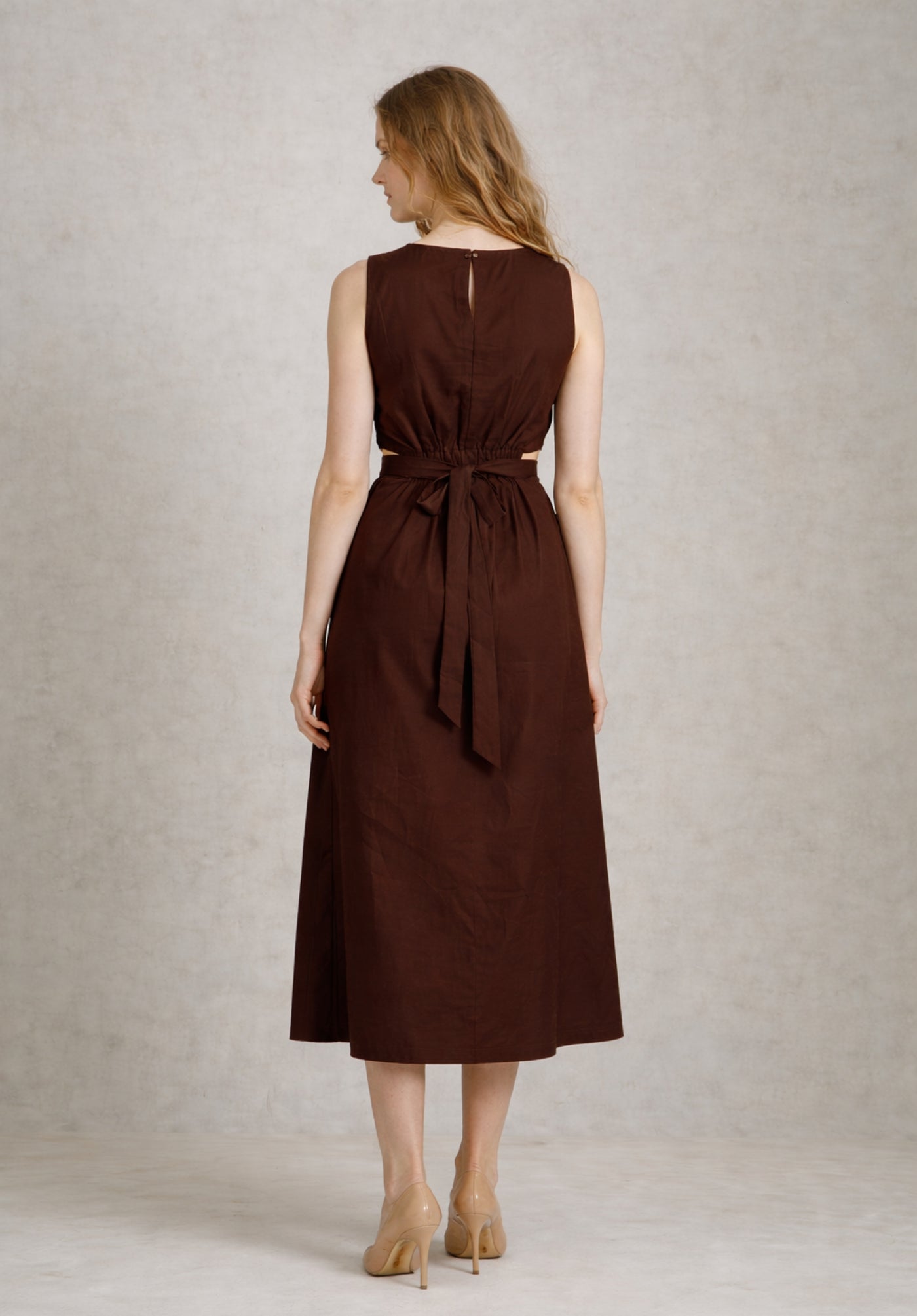 Lifestyle shot of brown cotton A-line dress styled with sandals
