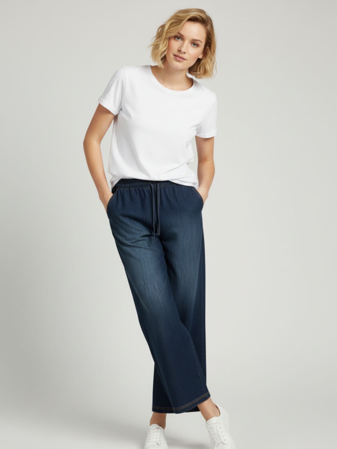 Close-up of drawstring waistband on dark blue denim trousers
