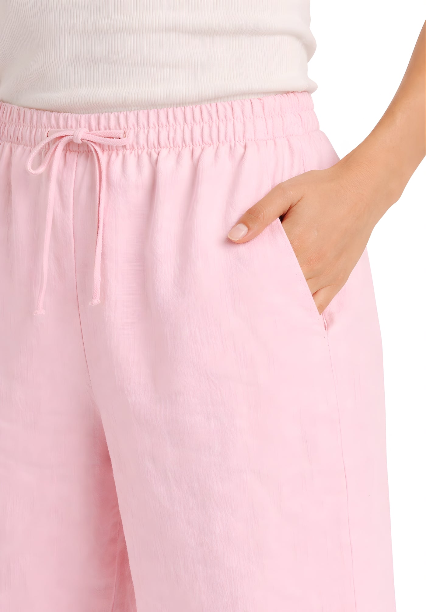 Detail of fabric texture on light pink linen blend baggy trousers
