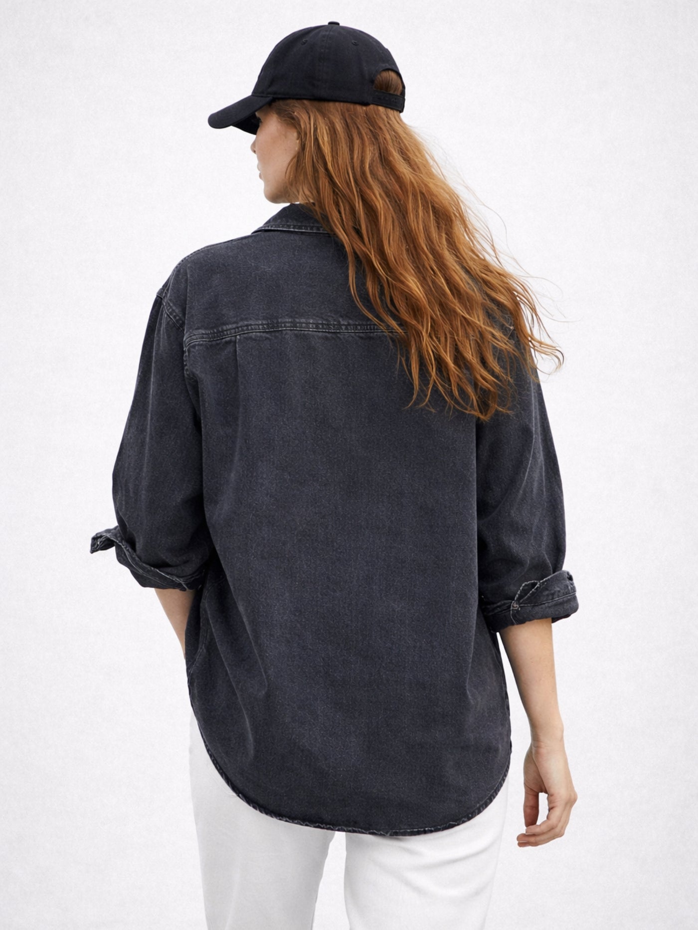 Lifestyle shot of woman wearing black oversized denim shirt