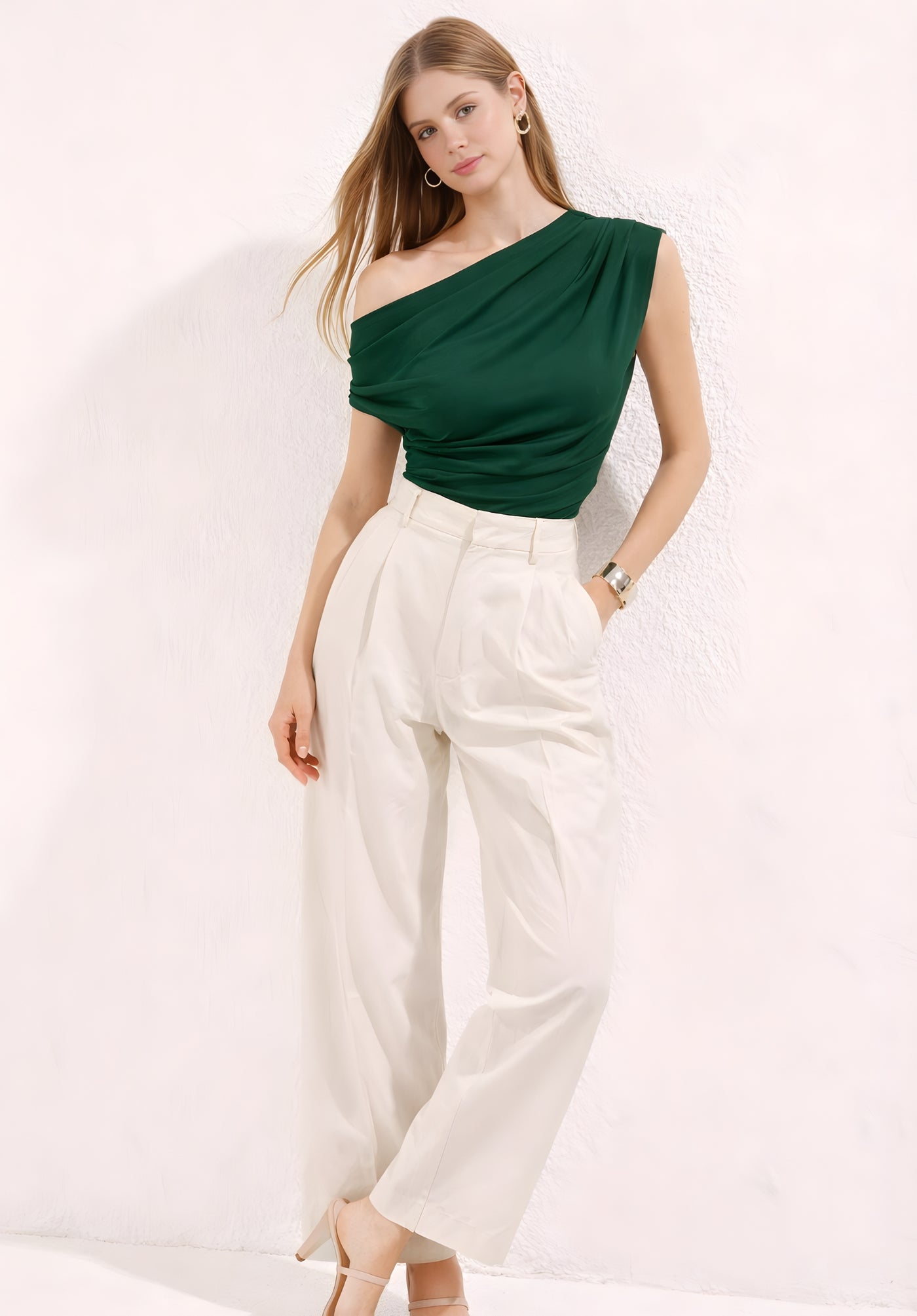 Lifestyle shot of green one-shoulder top styled with jeans