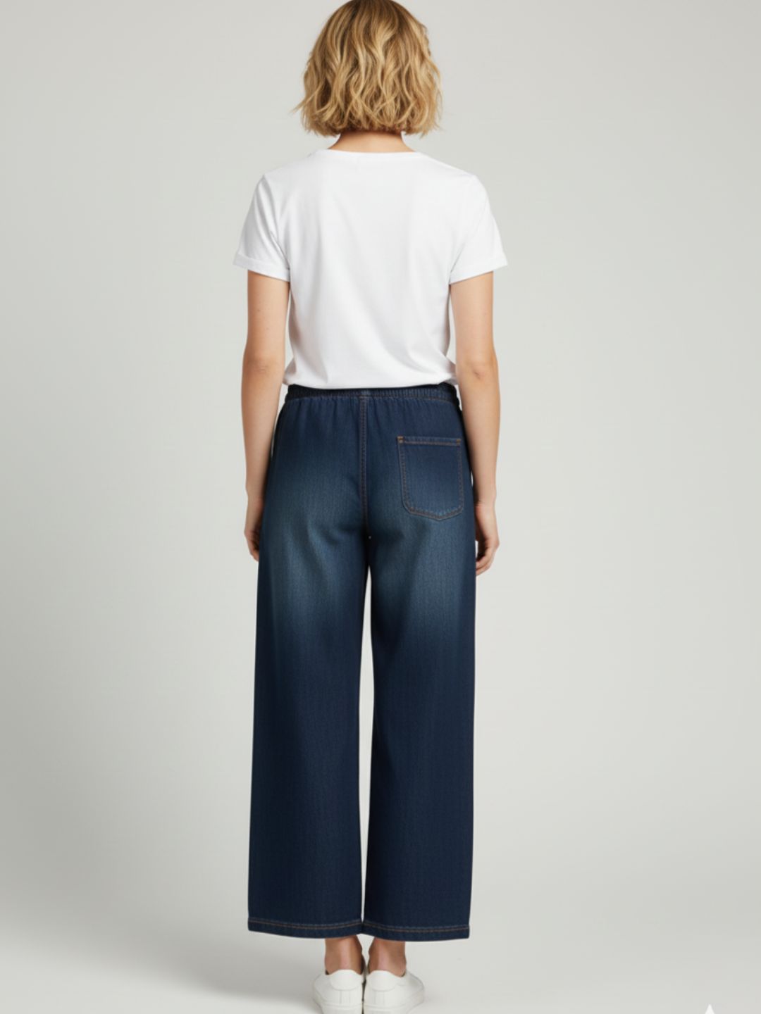 Detail of side pocket on dark blue denim drawstring trousers