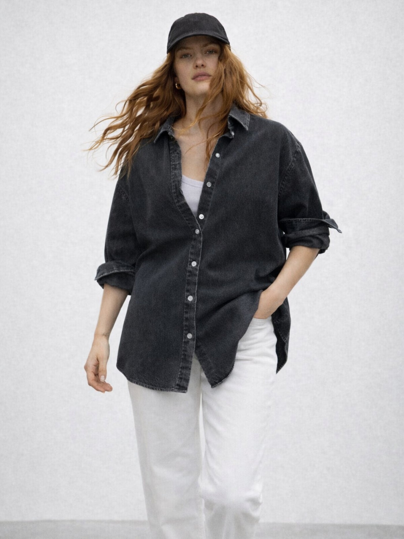 Detail of long sleeves and cuffs on black oversized denim shirt