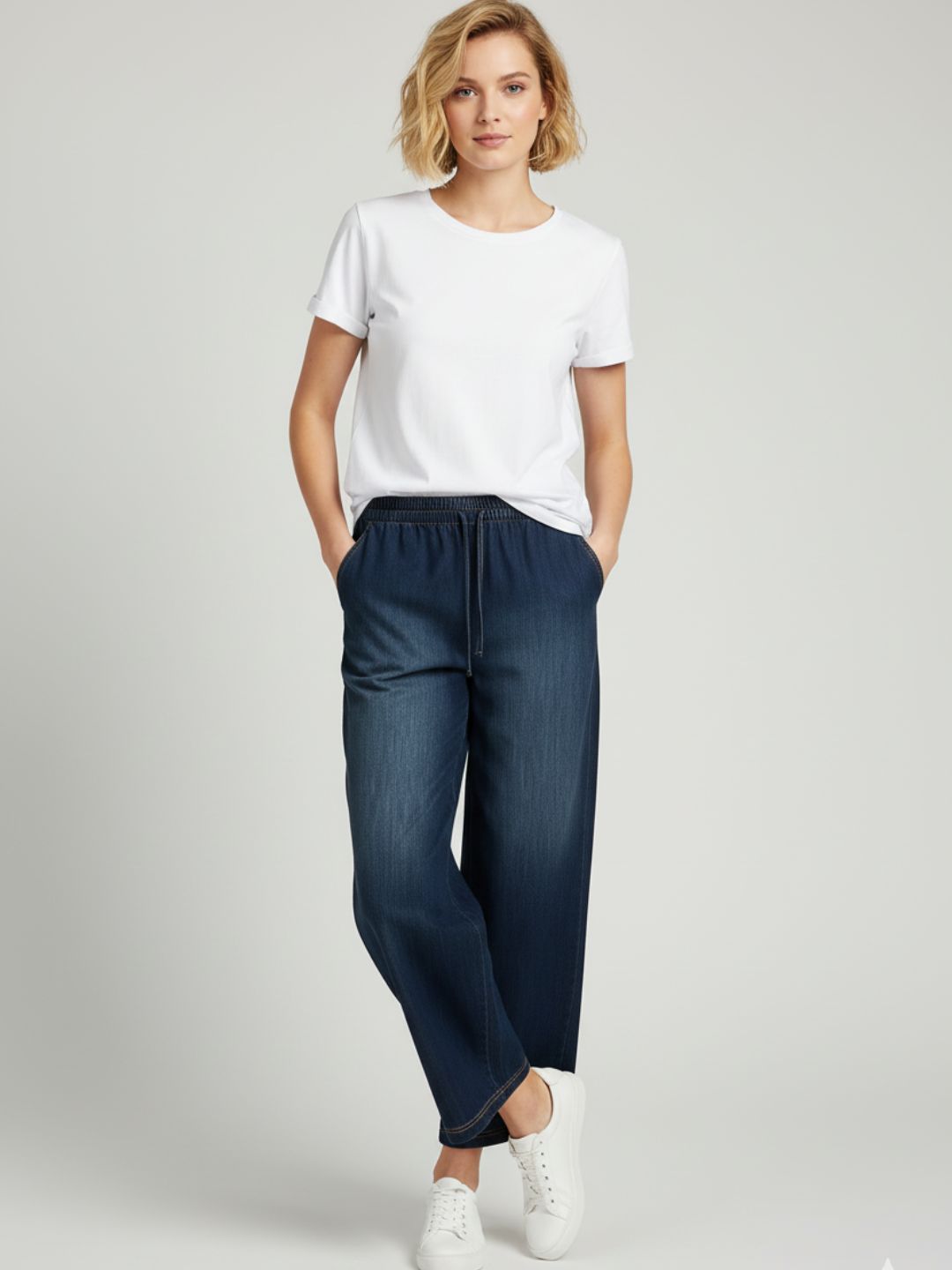 Lifestyle shot of dark blue denim drawstring trousers