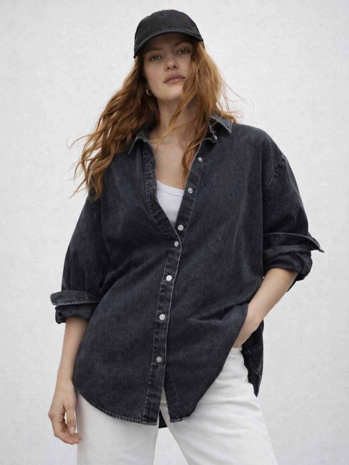 Styling shot of black oversized denim shirt knotted at waist