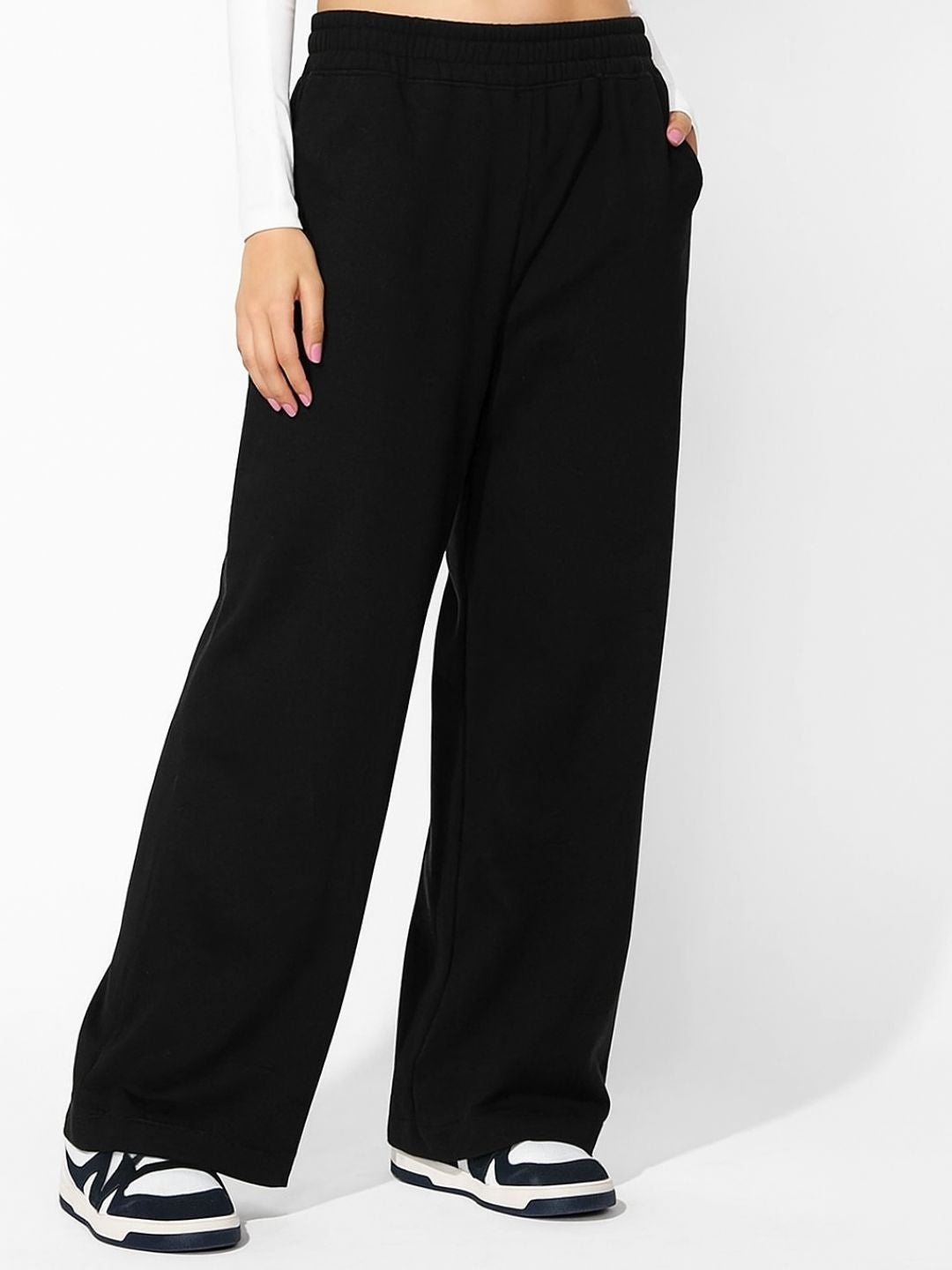 Black track pants styled with white tee and sneakers