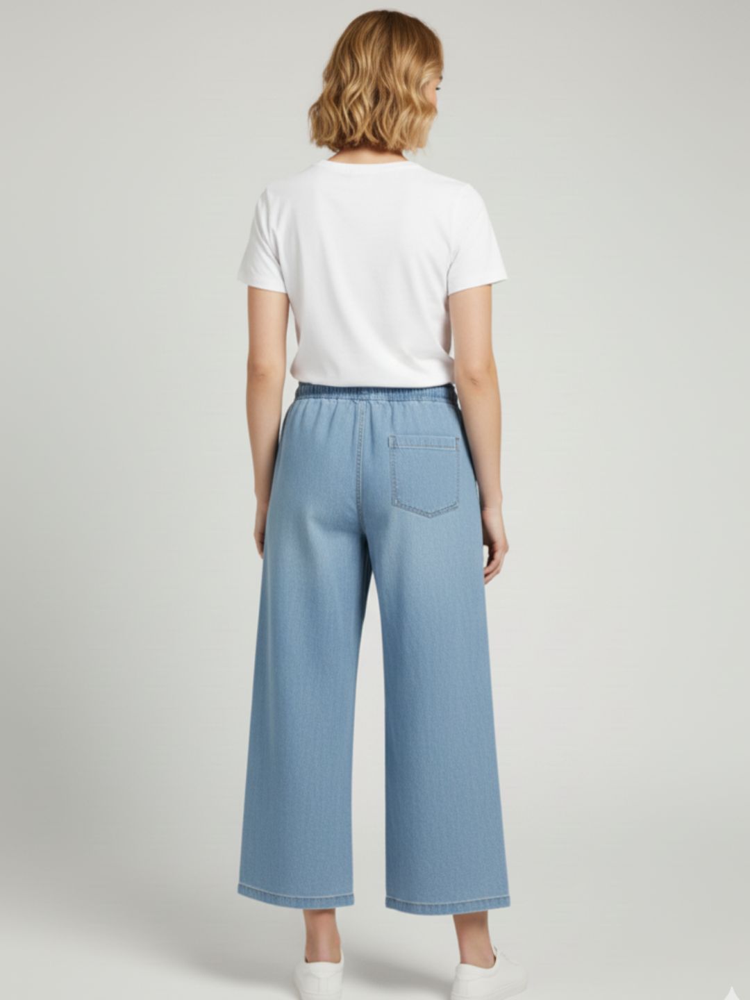 Lifestyle shot of light blue denim trousers styled with a tee