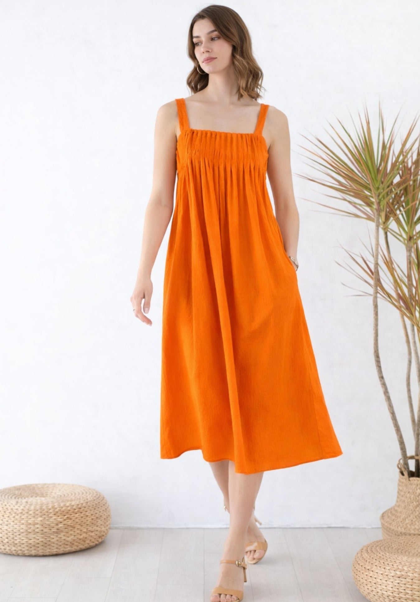 Back view of rust pleated pure cotton A-line dress on model