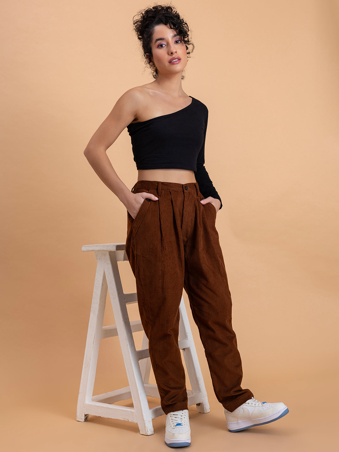 Full outfit view of brown corduroy baggy trousers paired with top