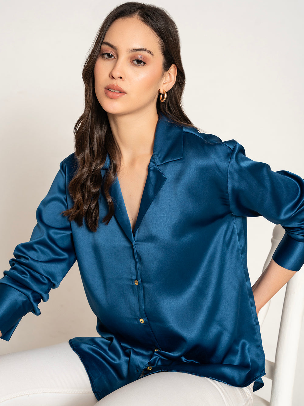 Lifestyle shot of woman wearing navy satin Cuban shirt