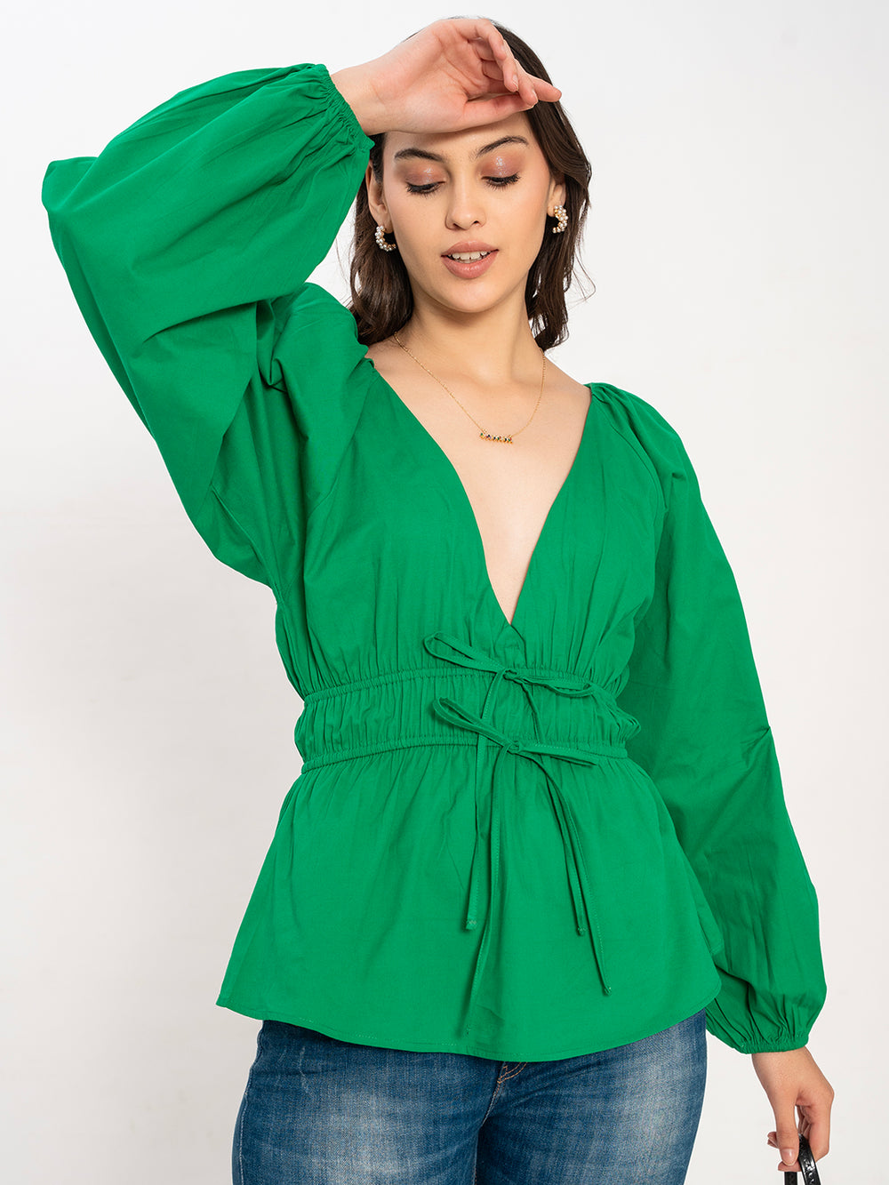 Lifestyle shot of woman wearing green cotton V-neck top