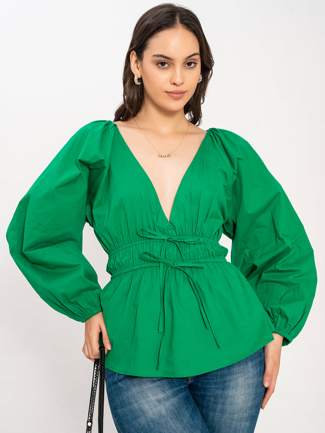 Side view of green poplin V-neck top showing buttoned cuffs
