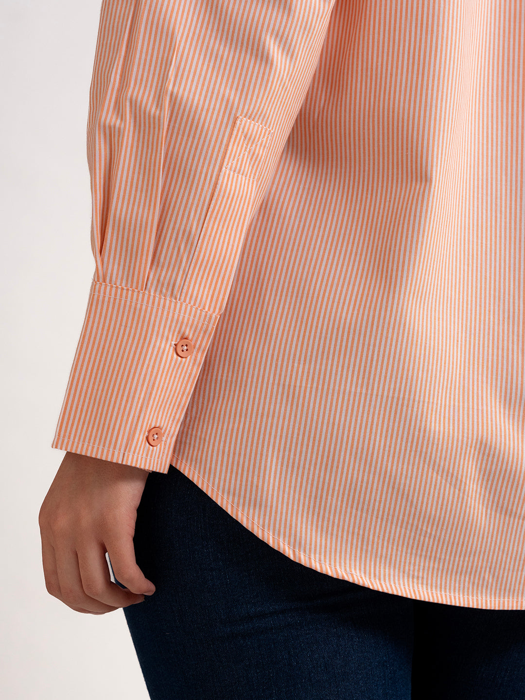 Styled view of orange striped shirt with denim