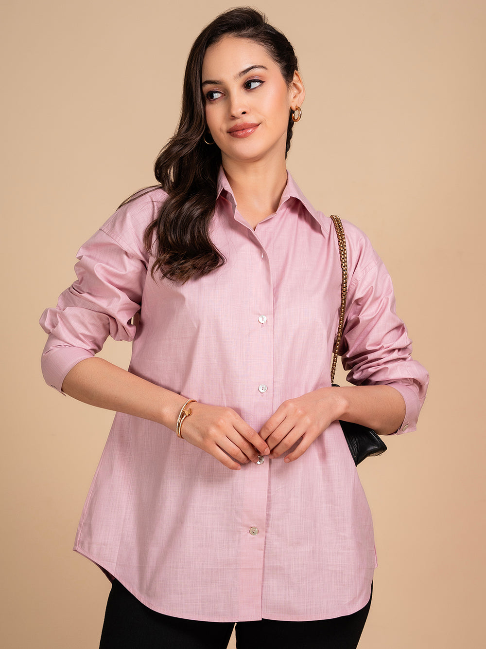 Lifestyle shot of woman wearing pink linen shirt