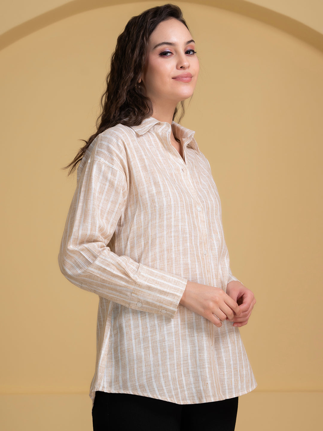 Lifestyle shot of woman wearing white and beige linen shirt