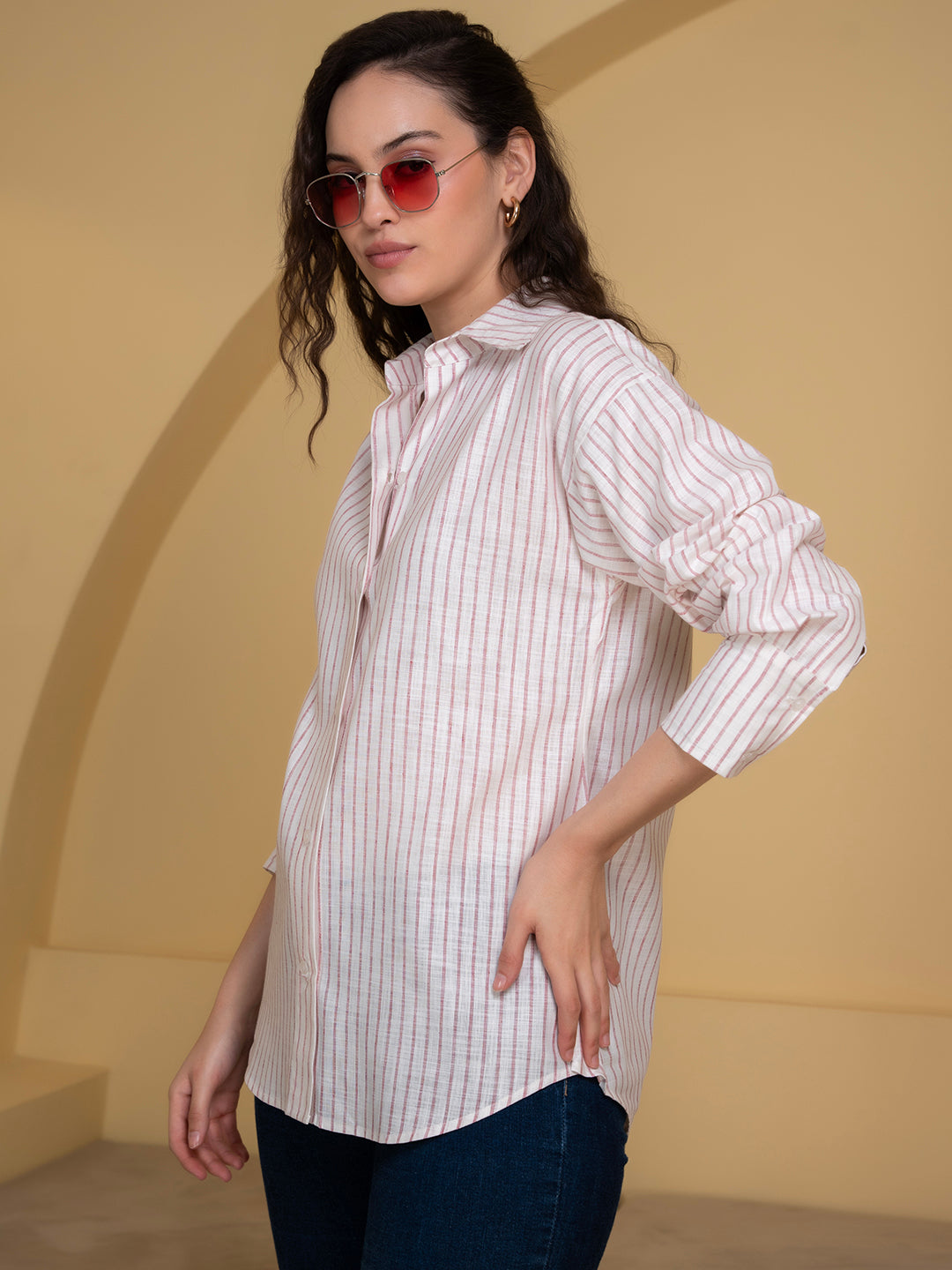 Lifestyle shot of woman wearing white and pink linen shirt