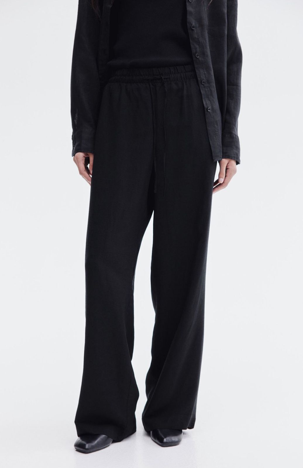 Detail of elasticated drawstring waist on black trousers
