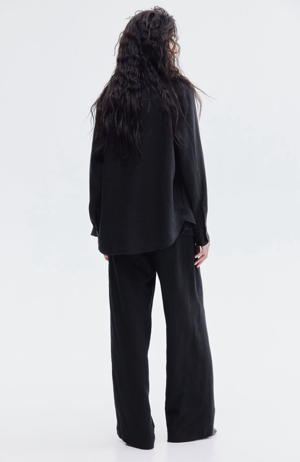 Back view of black linen blend baggy trousers