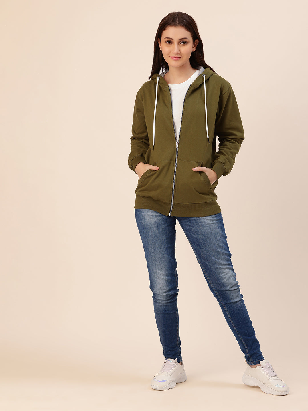 Lifestyle shot of woman wearing olive cotton fleece hoodie